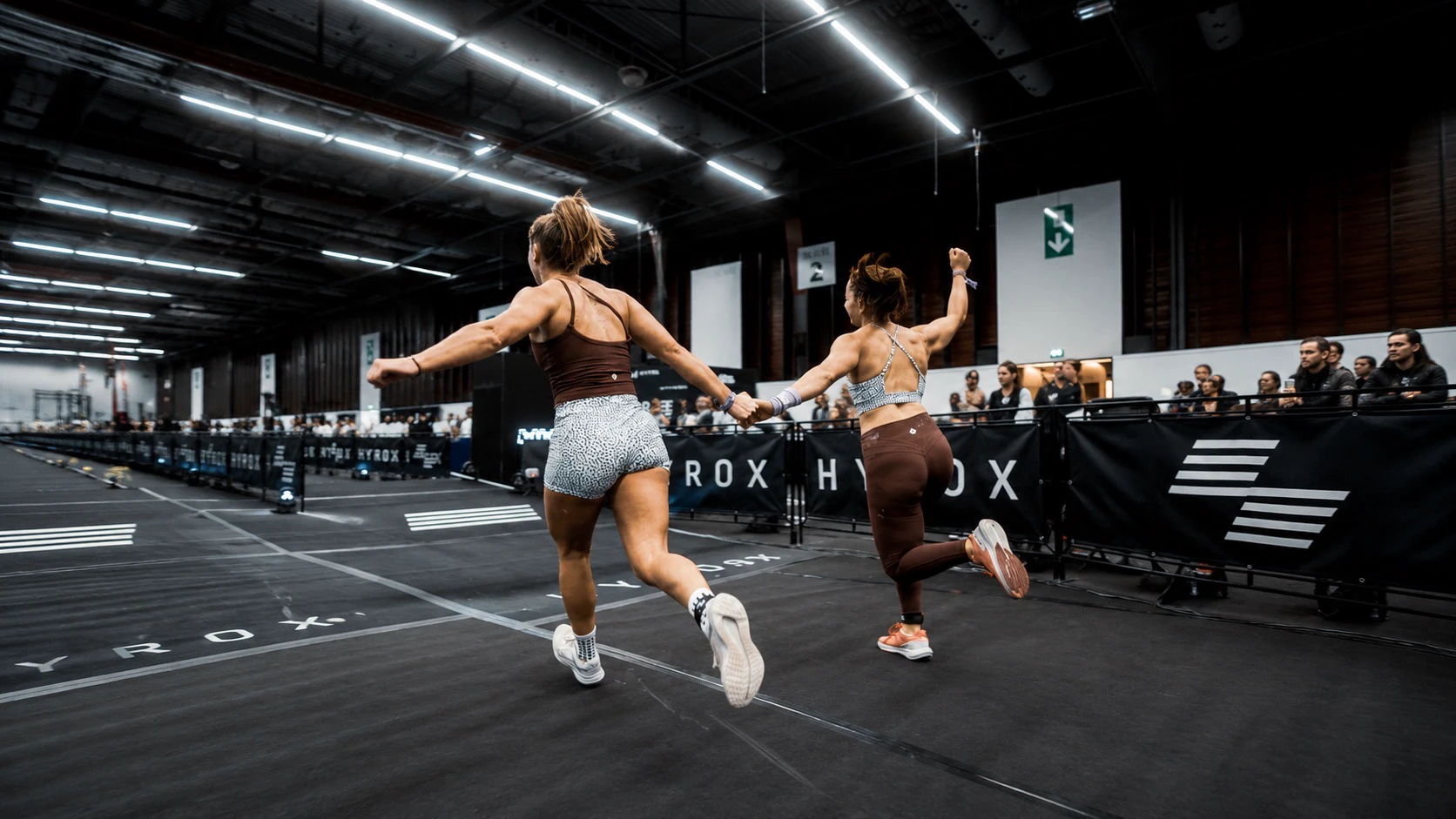 Athletes working through HYROX erg stations
