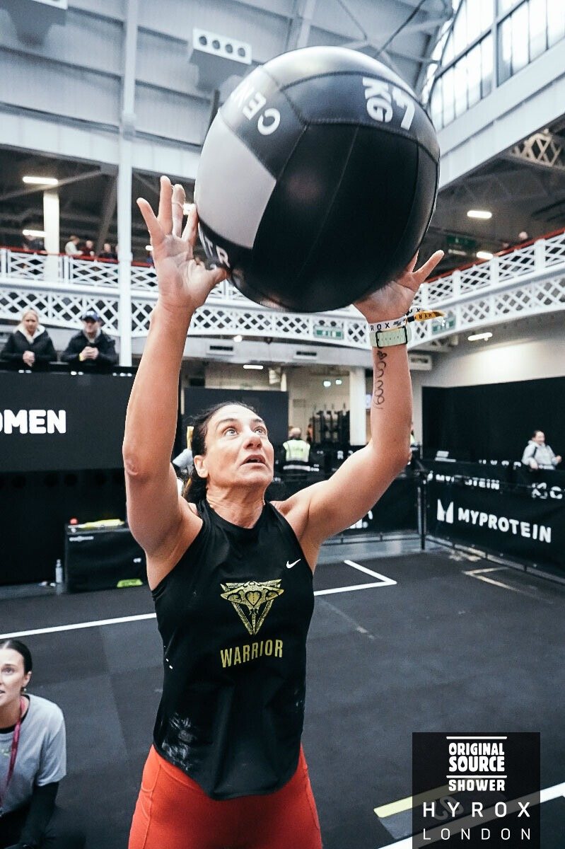 HYROX athlete completing wall balls during race day.